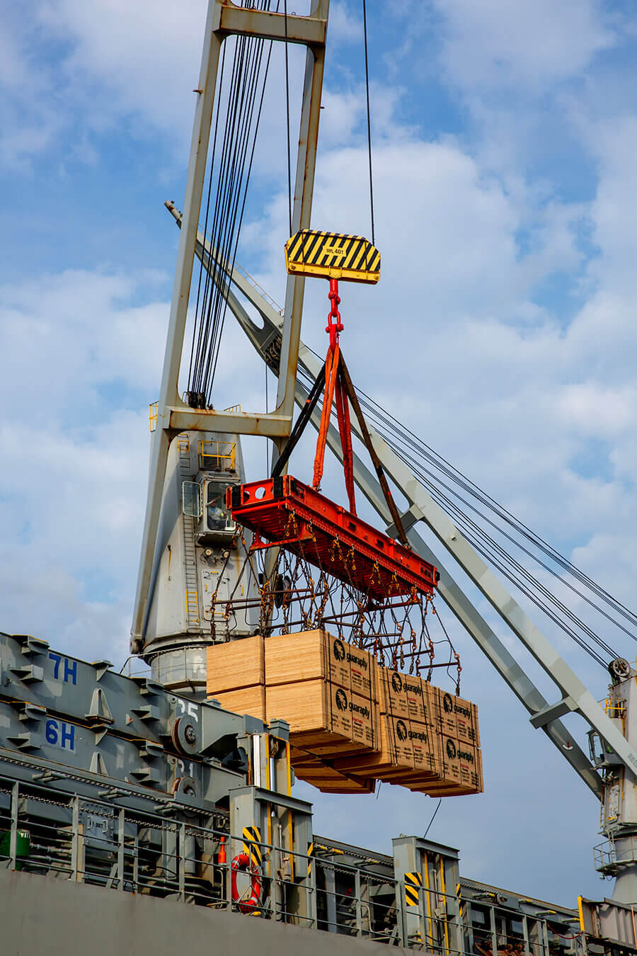 dimensional lumber being loaded onto truck using ship's crane