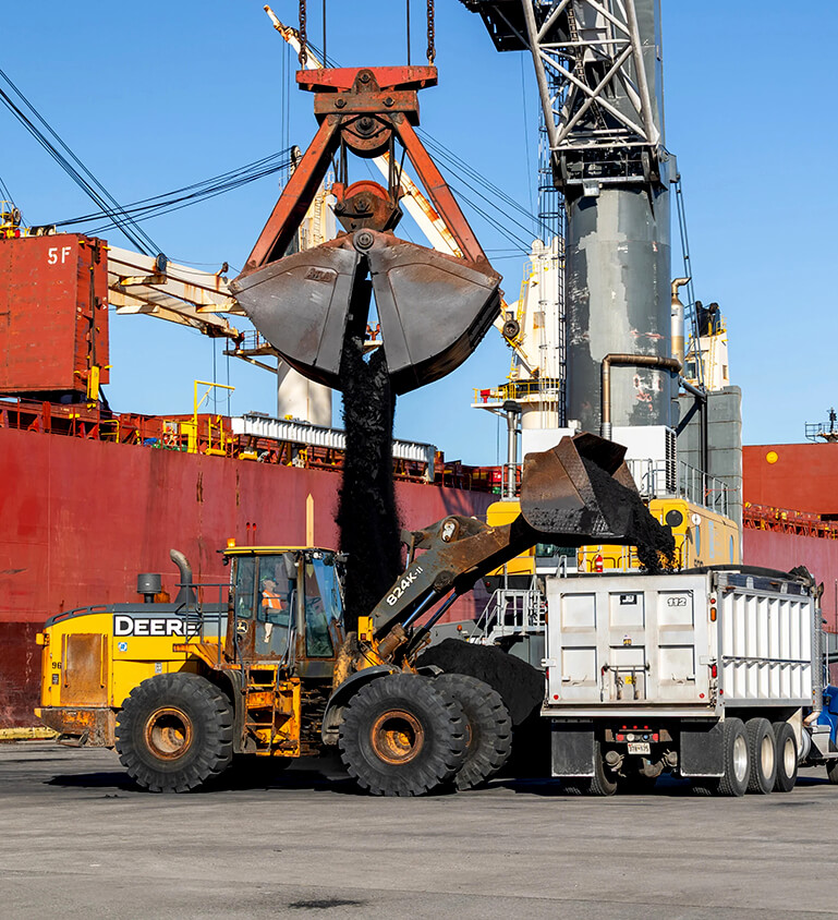 front end loader filling dump truck with bulk cargo