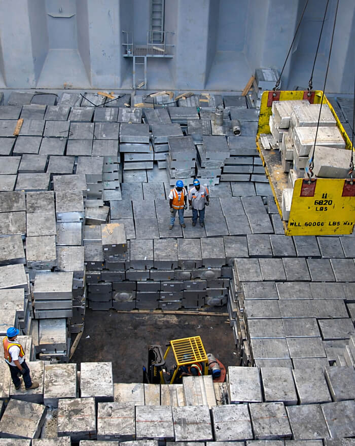 stevedores in ship's hold loading aluminum billets onto crane