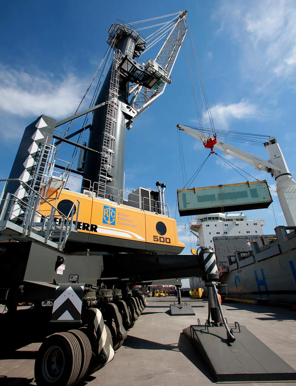 liebherr crane listing container from ship at pier