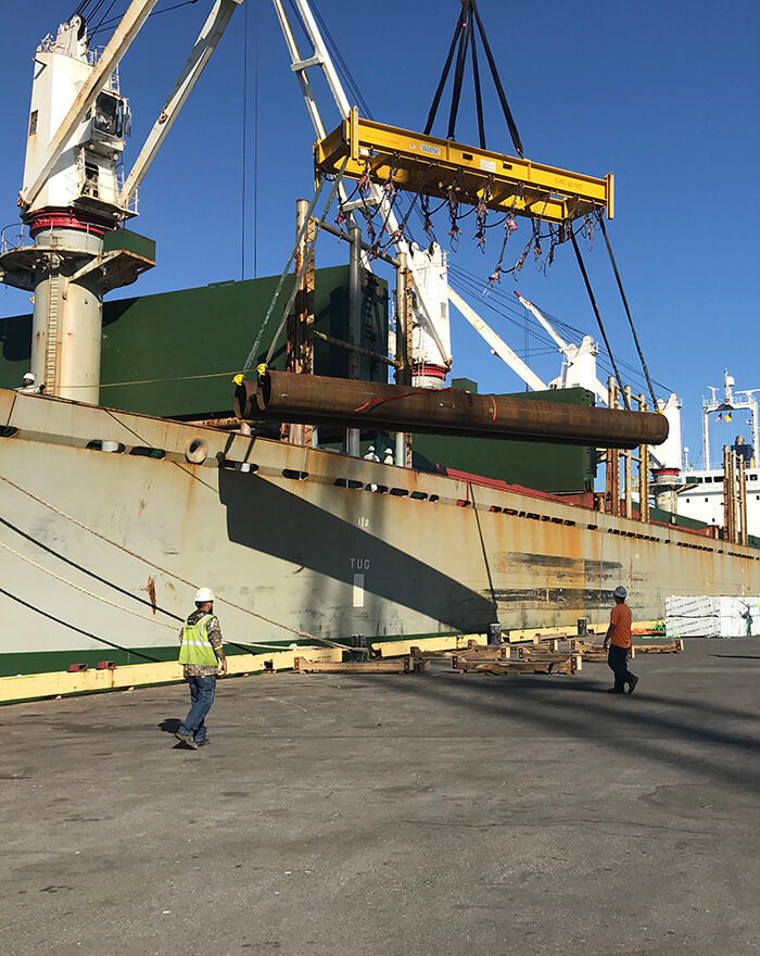 stevedores unloading steel products from a ship