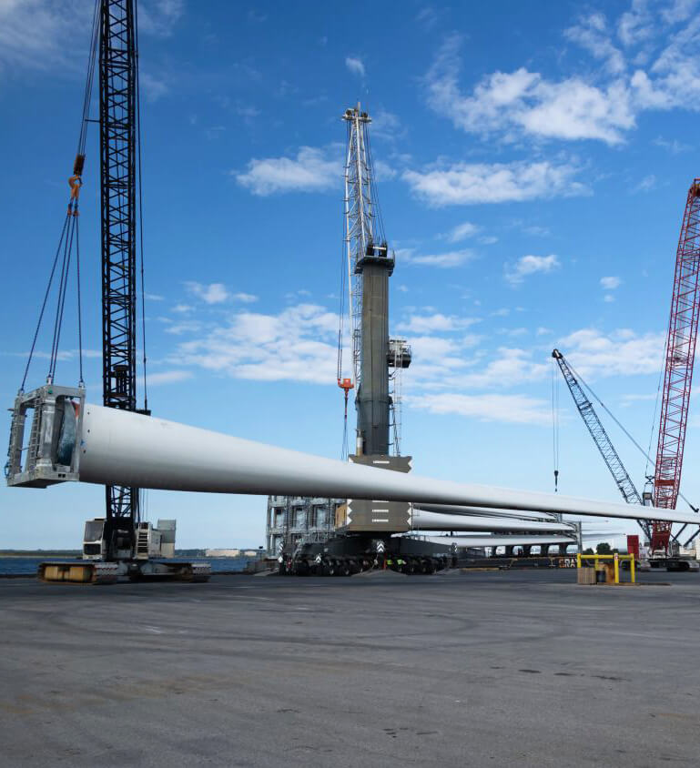 crane at pier listing wind turbine blades